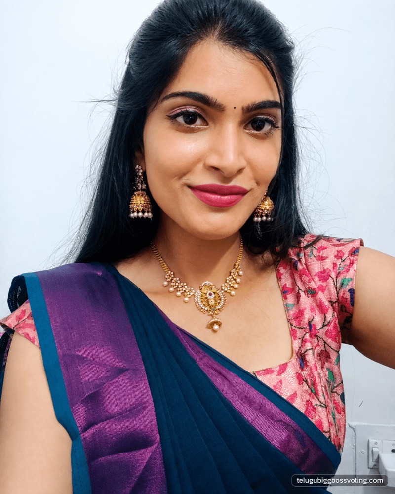 Illustrated selfie-style portrait of Gayathri Vardhan in a blue and purple saree with a pink floral blouse and gold jhumkas