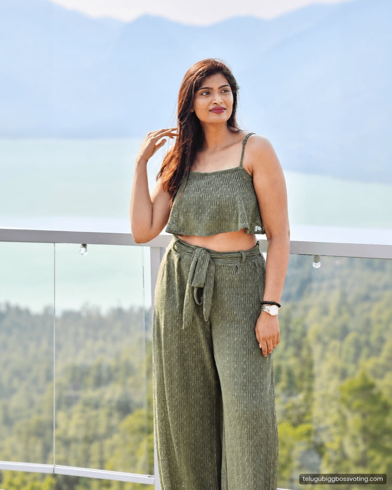 Illustrated portrait of Gayathri Vardhan in a green co-ord set on a glass balcony above a lake and forested hills