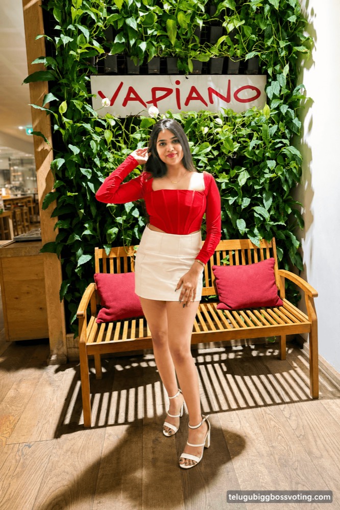 Illustrated portrait of Shalini Damera in a red top and white skirt outside a restaurant