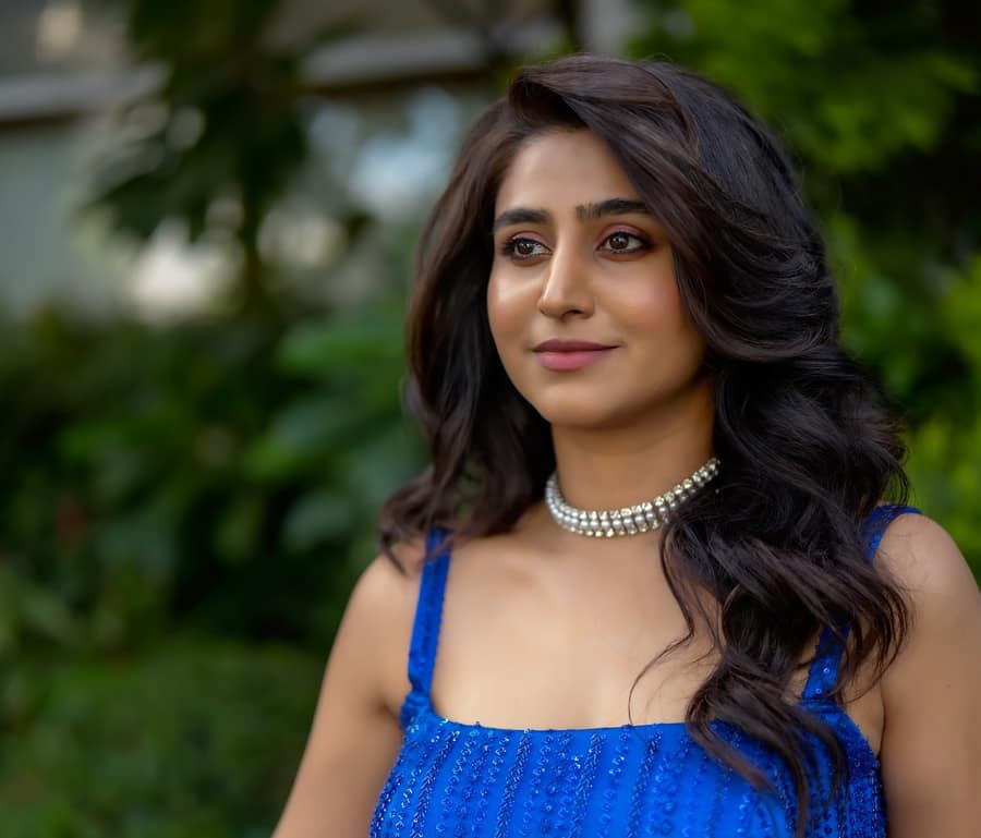 Varshini Sounderajan in a blue sequinned dress and a diamond choker, outdoors