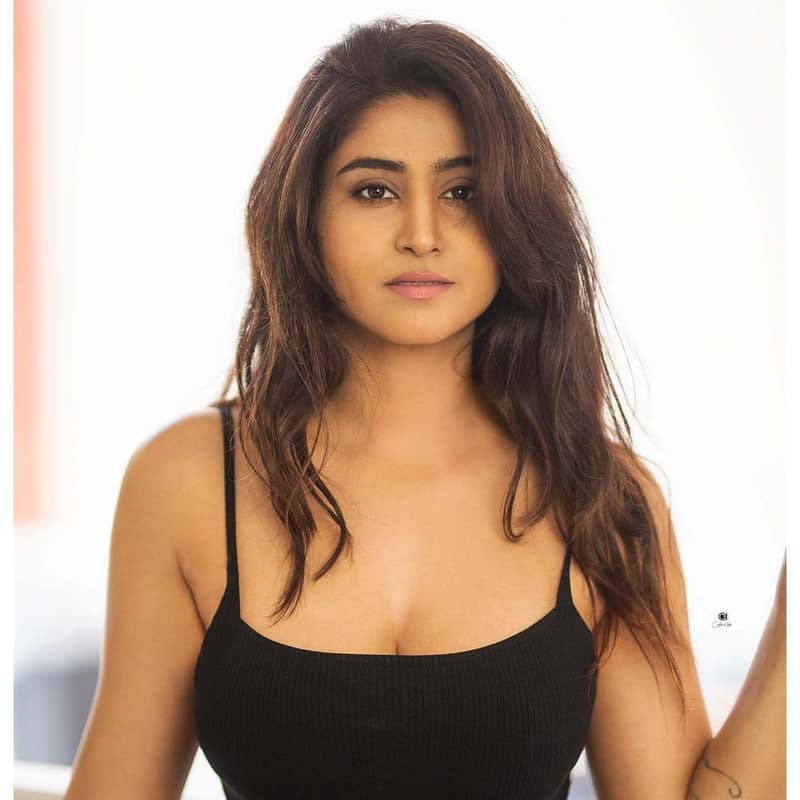 Varshini Sounderajan in a black top against a white wall, from her own Instagram feed